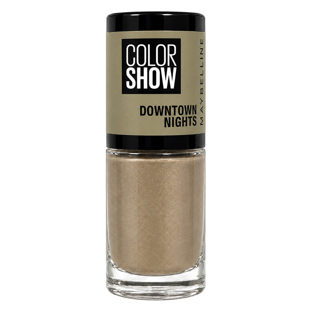 Maybelline Color Show Downtown Nights nail polish in a clear glass bottle with a black cap and a beige label, showing a shimmering champagne-gold liquid inside.