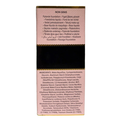 A rectangular foundation stick package shown upright on a white background. The top portion is a dusty pink panel with product name and text, the center is a black band, and the bottom portion is a light pink panel with ingredients listed in small print.