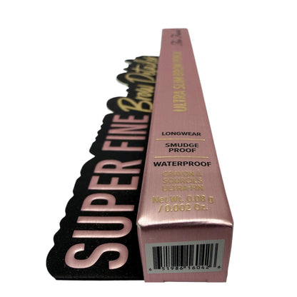 A slim rectangular box for a makeup product in a dusty pink metallic finish with gold text, shown standing upright next to a black scalloped card that reads 'SUPER FINE Brow Product' in large pink letters. The box includes product claims such as longwear, smudge proof, and waterproof, plus a barcode near the bottom.